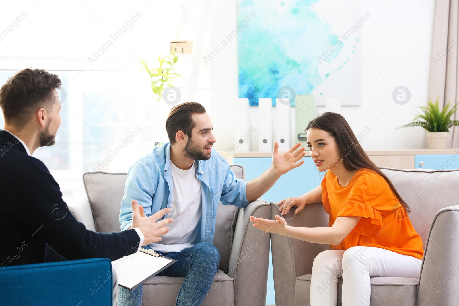 Photo of Family psychologist working with young couple in office