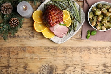 Photo of Festive flat lay composition with delicious ham on wooden table, space for text. Christmas dinner