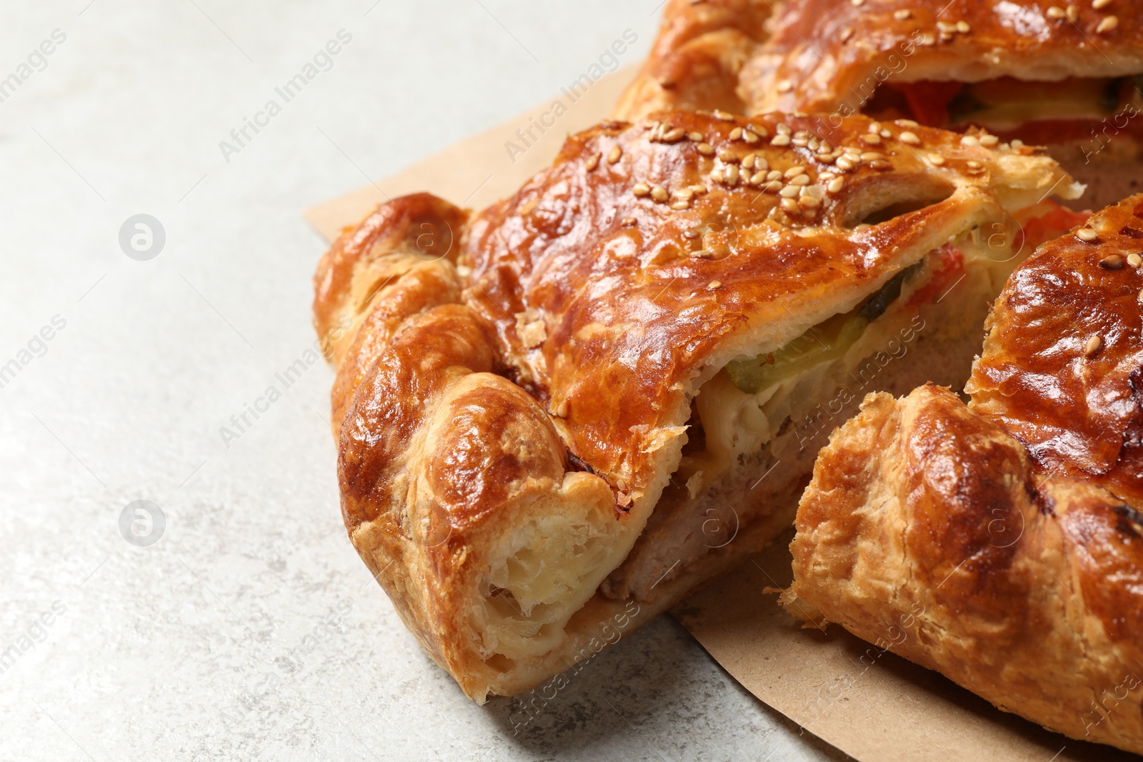 Photo of Cut delicious homemade pie on light grey table, closeup