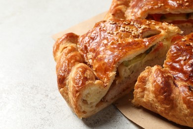 Photo of Cut delicious homemade pie on light grey table, closeup