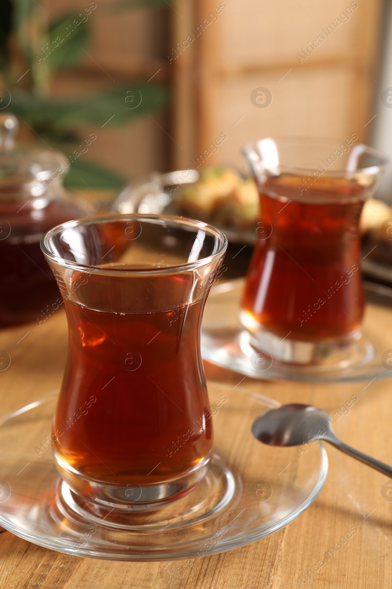 Photo of Traditional Turkish tea in glasses on wooden table, closeup