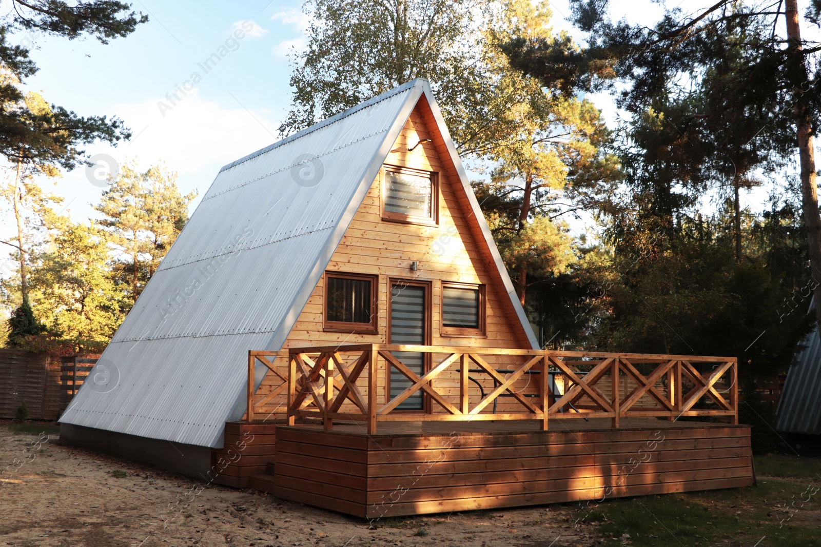 Photo of Picturesque view of modern wooden house with veranda near forest on sunny day