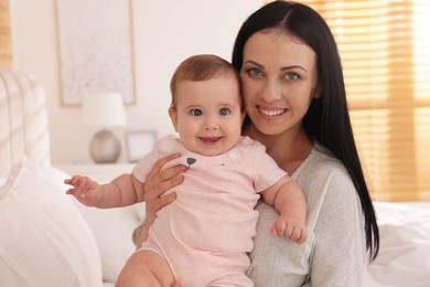 Happy woman with her little baby on bed at home