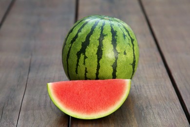 Photo of Whole and cut delicious ripe watermelons on wooden table