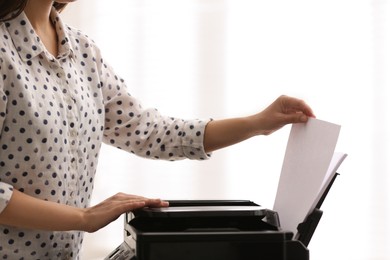 Photo of Employee using modern printer in office, closeup