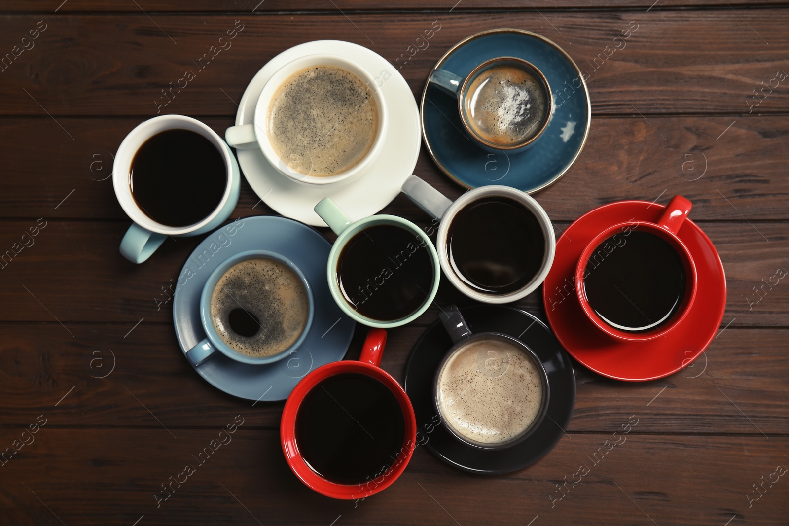 Photo of Flat lay composition with cups of coffee on wooden background. Food photography