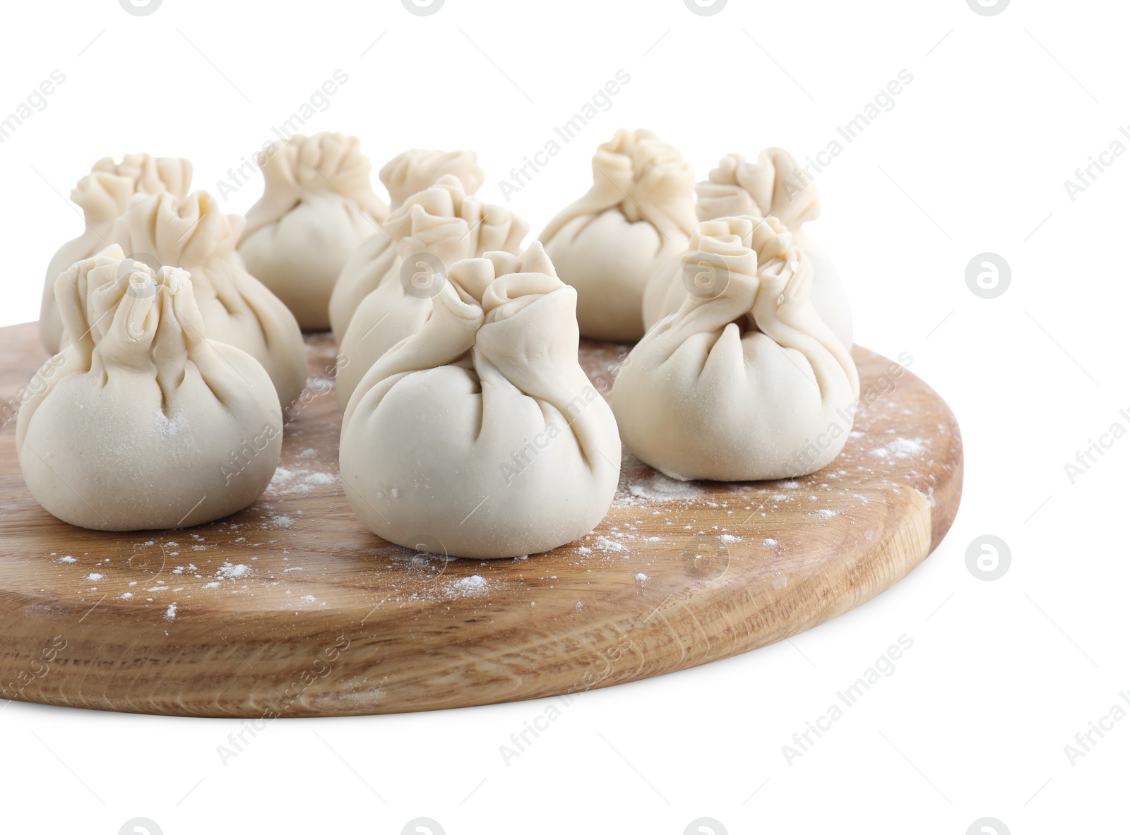 Photo of Wooden board with uncooked khinkali (dumplings) isolated on white. Georgian cuisine