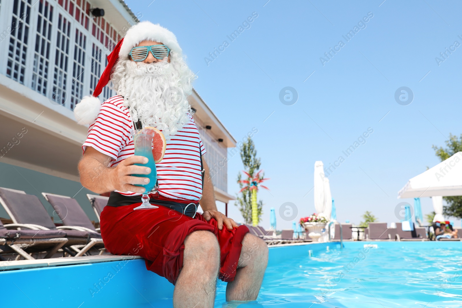 Photo of Authentic Santa Claus with cocktail near pool at resort