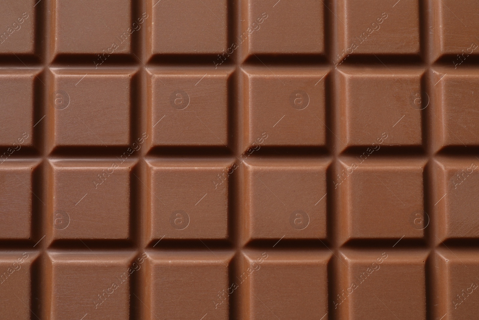 Photo of Delicious milk chocolate bar as background, top view