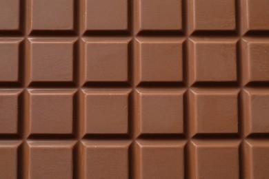 Delicious milk chocolate bar as background, top view