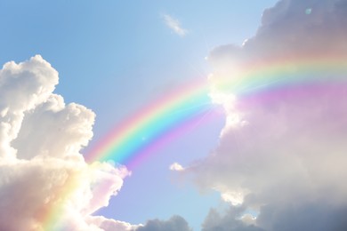 Image of Beautiful view of bright rainbow in blue sky on sunny day