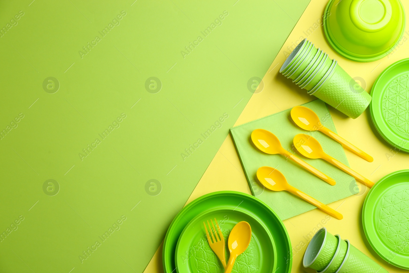 Photo of New plastic dishware and space for text on color background. Table setting