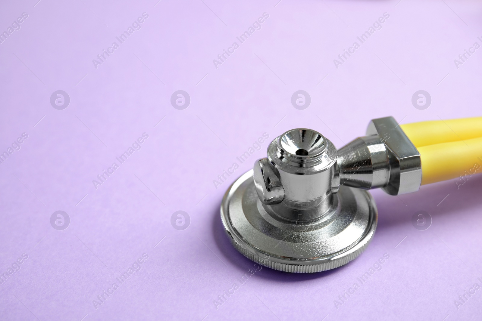 Photo of Stethoscope with space for text on color background, closeup. Medical tool