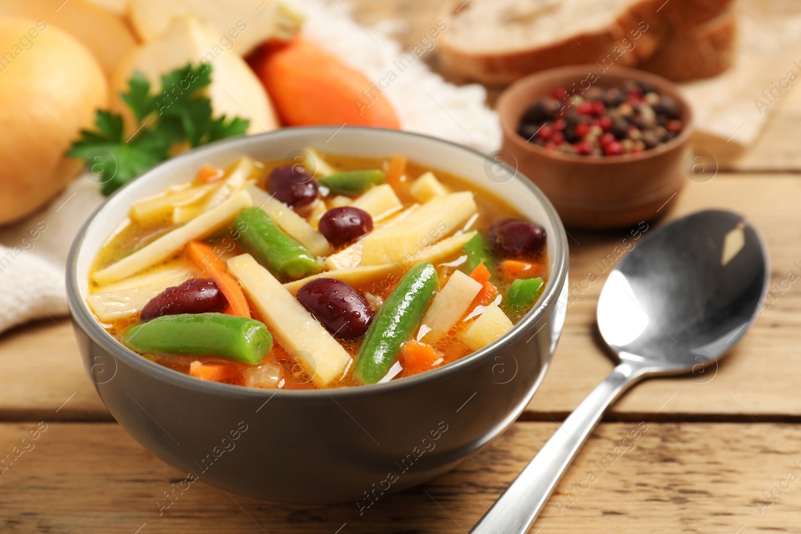 Photo of Bowl of delicious turnip soup served on wooden table