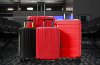 Stylish suitcases in waiting area at airport terminal