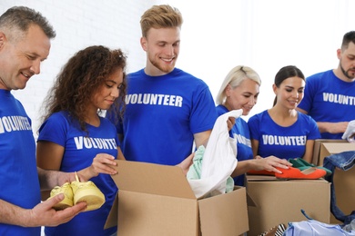 Team of volunteers collecting donations in boxes indoors