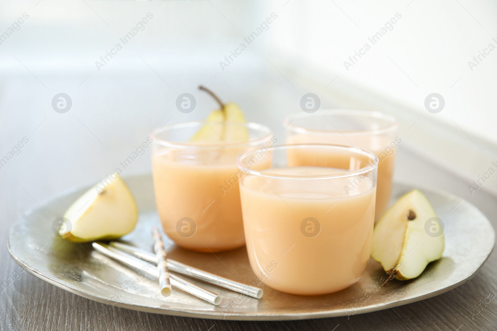 Photo of Tasty pear juice and cut fruit on wooden table, closeup