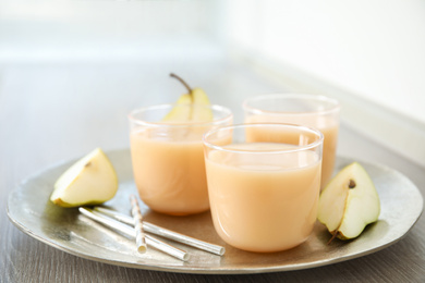 Tasty pear juice and cut fruit on wooden table, closeup