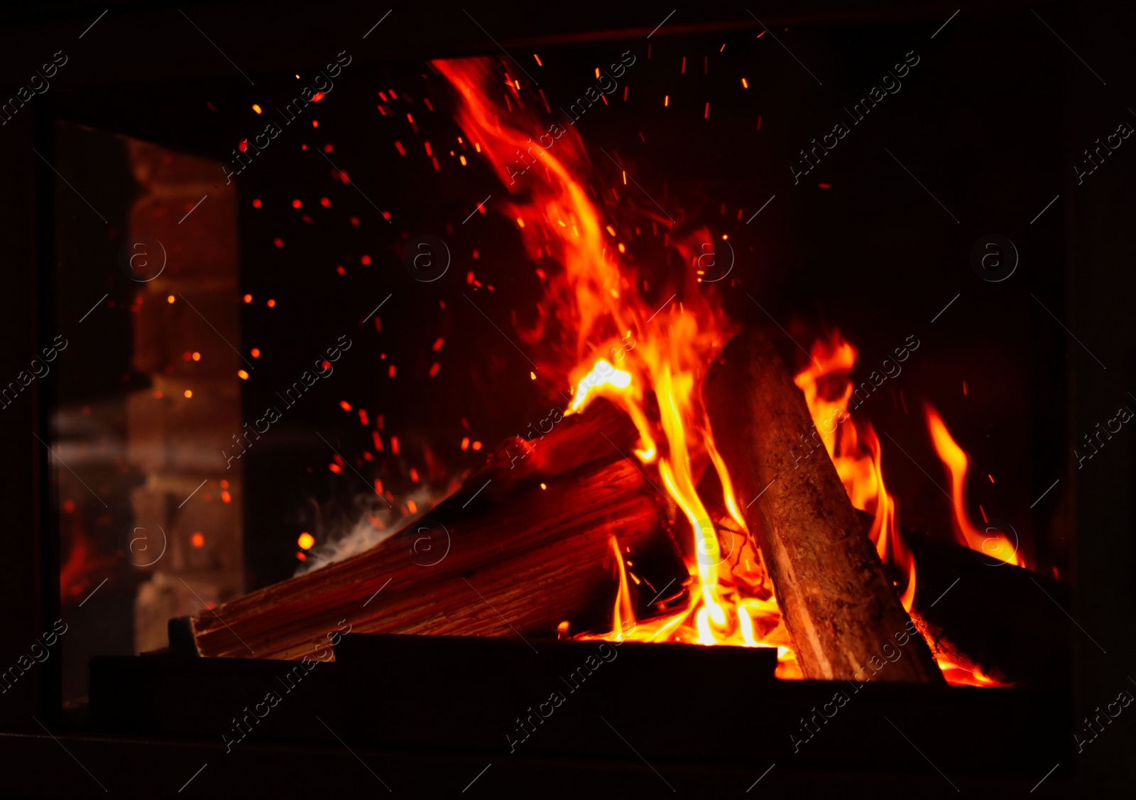 Photo of Fireplace with burning wood, closeup view. Winter vacation