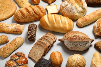 Photo of Different kinds of fresh bread on light background