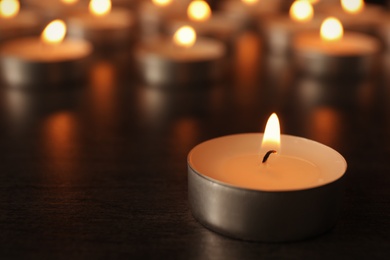 Photo of Burning candles on wooden table, space for text. Symbol of sorrow