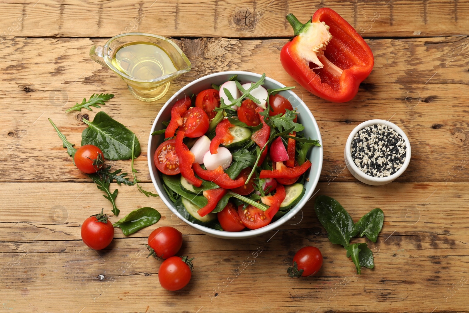 Photo of Tasty fresh vegetarian salad on wooden table, flat lay