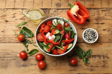 Photo of Tasty fresh vegetarian salad on wooden table, flat lay