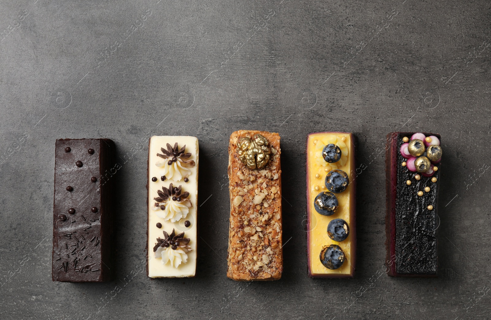 Photo of Different delicious cakes on grey table, flat lay. Space for text