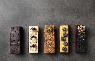 Photo of Different delicious cakes on grey table, flat lay. Space for text