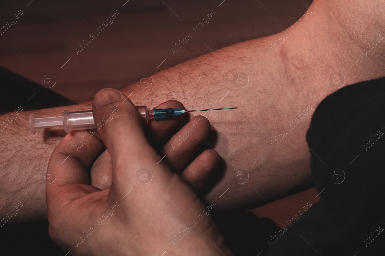 Photo of Man taking drugs on dark background, closeup