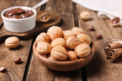 Photo of Homemade walnut shaped cookies with boiled condensed milk on wooden table