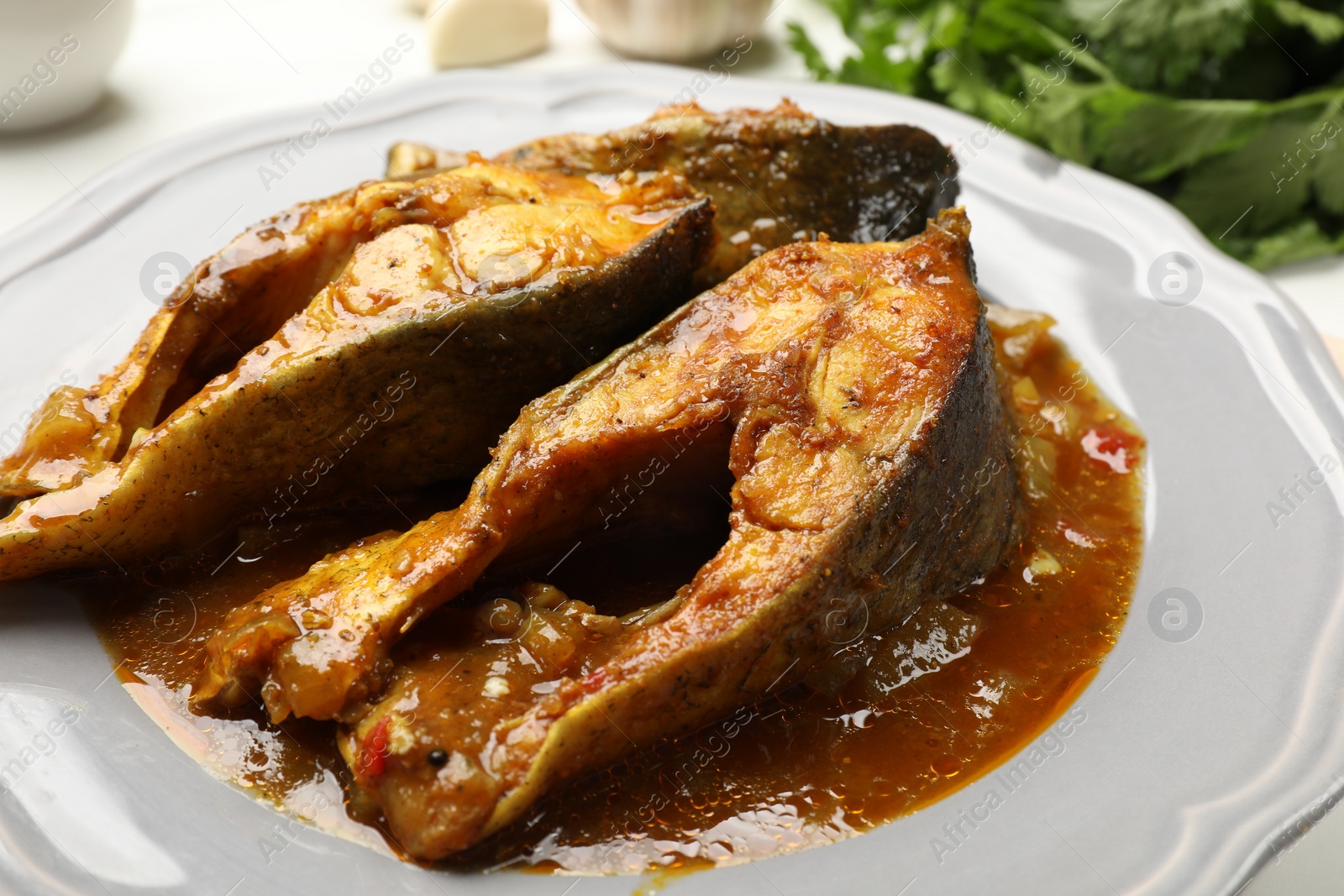 Photo of Tasty fish curry on white table, closeup. Indian cuisine