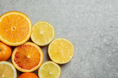 Different citrus fruits on grey background, flat lay. Space for text