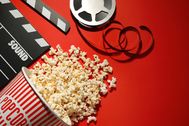 Photo of Flat lay composition with delicious popcorn on red background