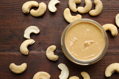 Photo of Delicious cashew butter and ingredients on wooden table, flat lay