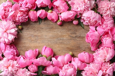 Frame made of fragrant on wooden table, top view with space for text. Beautiful spring flowers