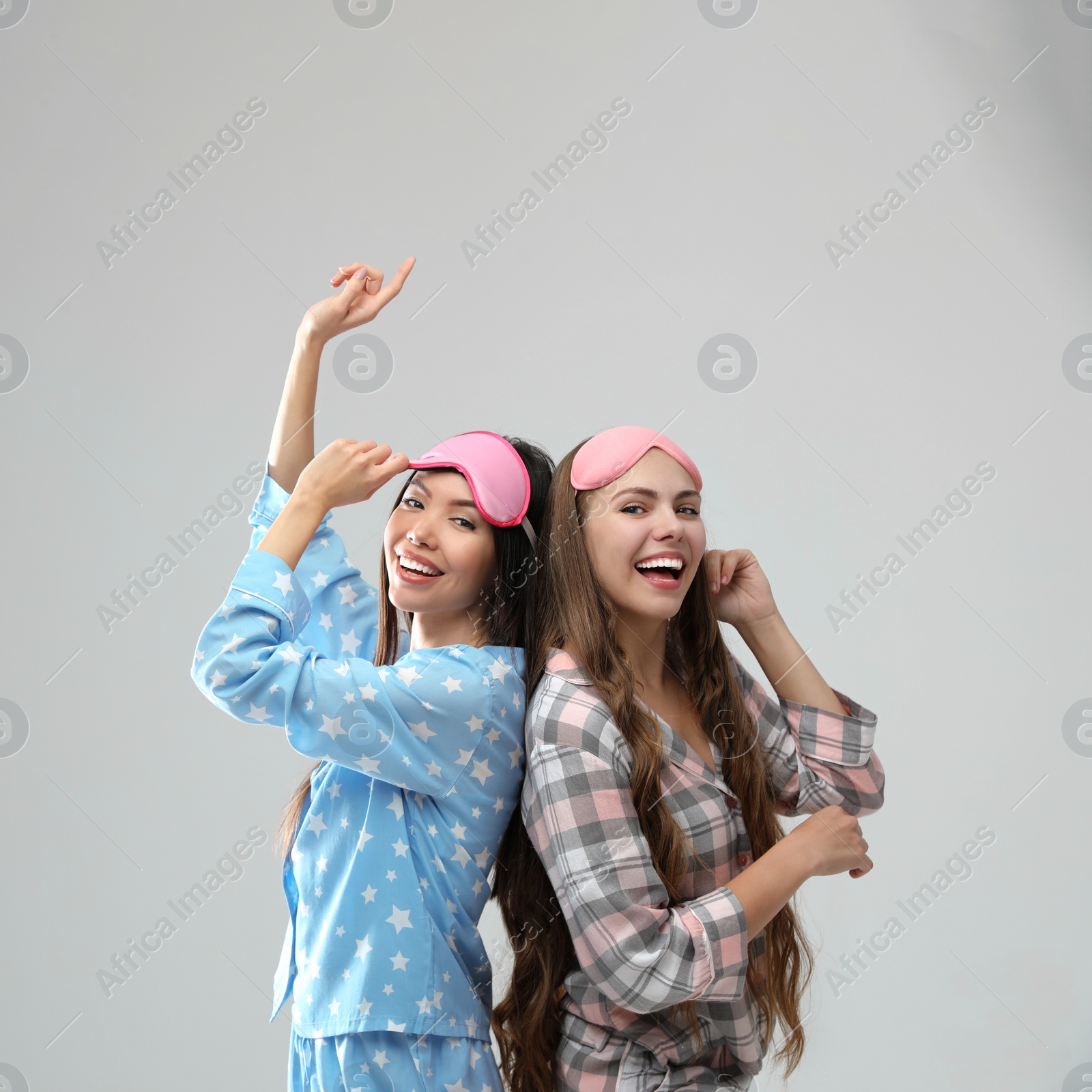 Photo of Beautiful women in pajamas on light grey background. Bedtime