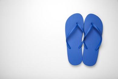 Photo of Blue flip flops on white background, top view. Space for text