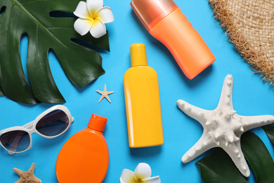 Photo of Flat lay composition with sun protection products on blue background