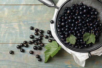 Ripe blackcurrants and leaves on wooden rustic table, flat lay. Space for text