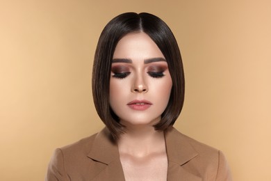 Image of Portrait of stylish young woman with brown hair on beige background