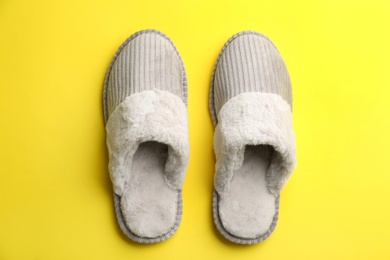 Photo of Pair of soft slippers on yellow background, flat lay