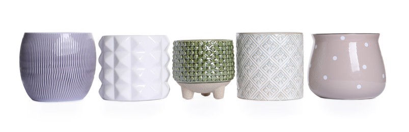 Different stylish ceramic flowerpots on white background