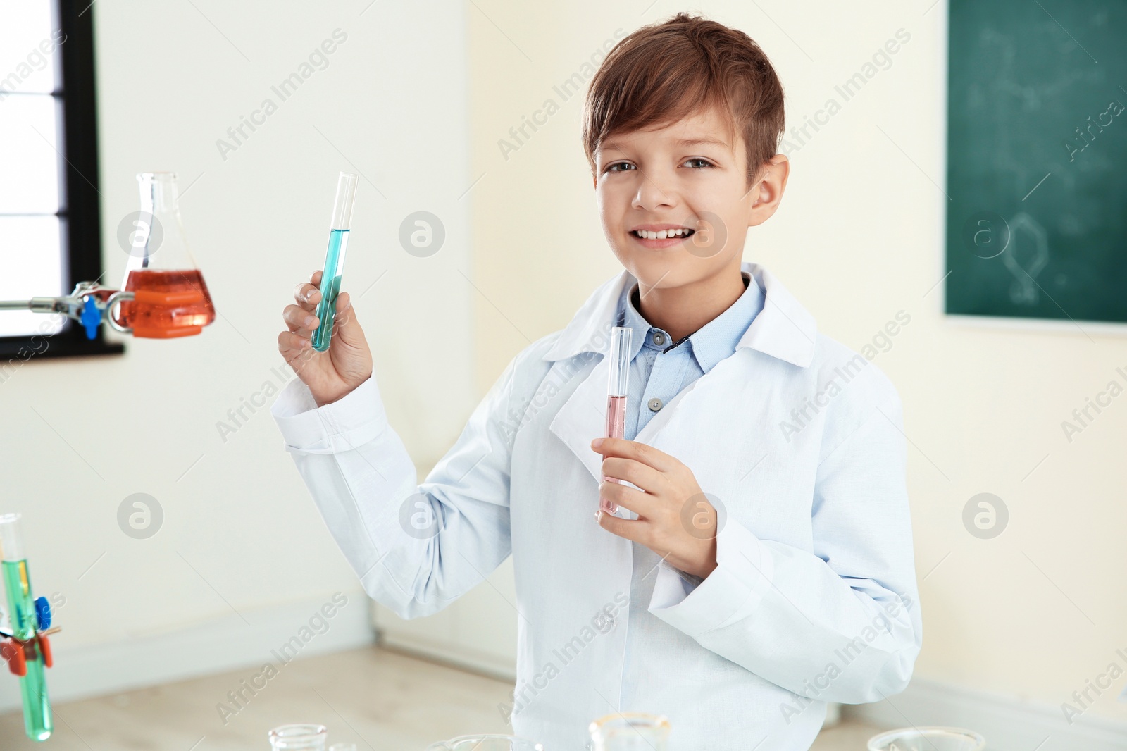 Photo of Smart pupil with test tubes in chemistry class