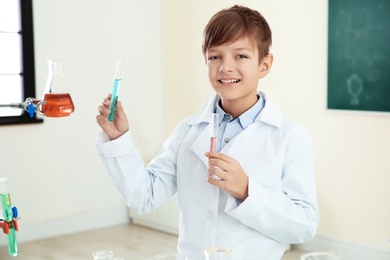 Photo of Smart pupil with test tubes in chemistry class