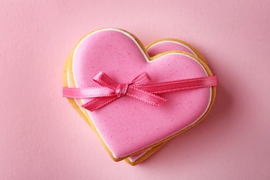 Decorated heart shaped cookies on color background, top view