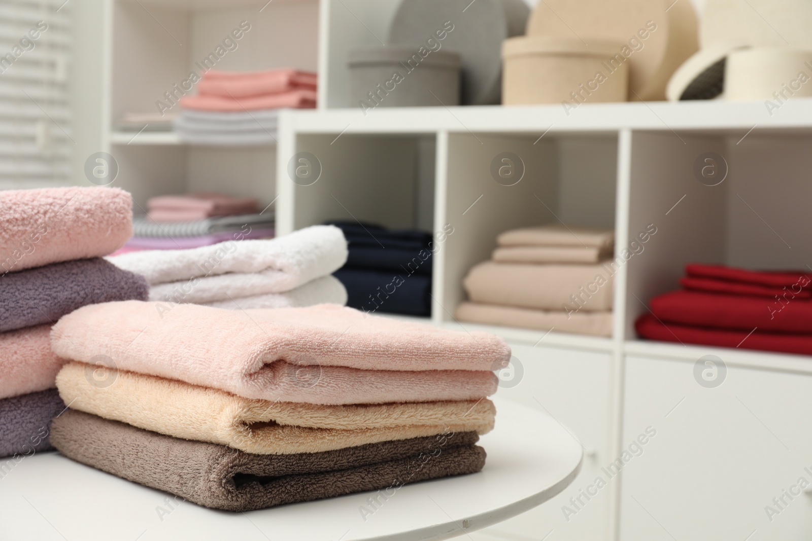 Photo of Stacked towels, decorative boxes and colorful bed linens in shop