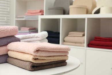 Stacked towels, decorative boxes and colorful bed linens in shop