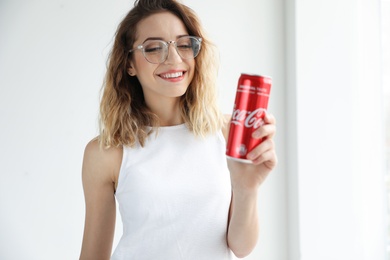 MYKOLAIV, UKRAINE - NOVEMBER 28, 2018: Young woman with Coca-Cola can indoors