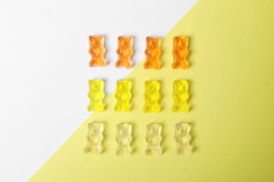 Delicious jelly bears on color background, top view